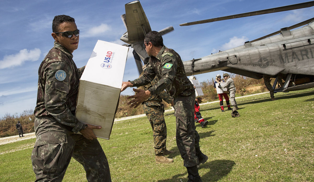 Des Casques bleus brésiliens de la Mission des Nations Unies en Haïti (MINUSTAH) aident à décharger un hélicoptère militaire de ravitaillement.