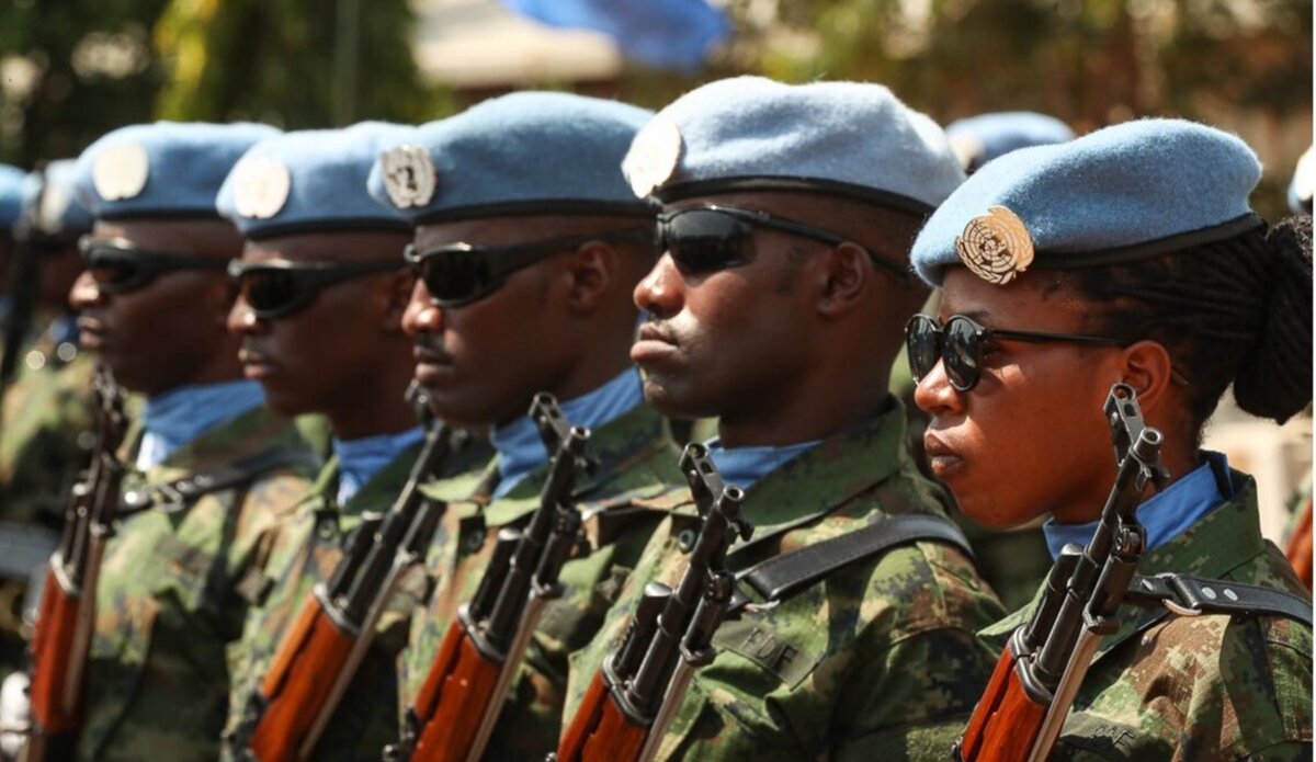 UN soldiers stand in a row, with one woman standing at the front. 